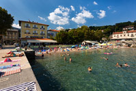People swimming on popular beach in place Ika near town Opatija, Kvarner, Croatia